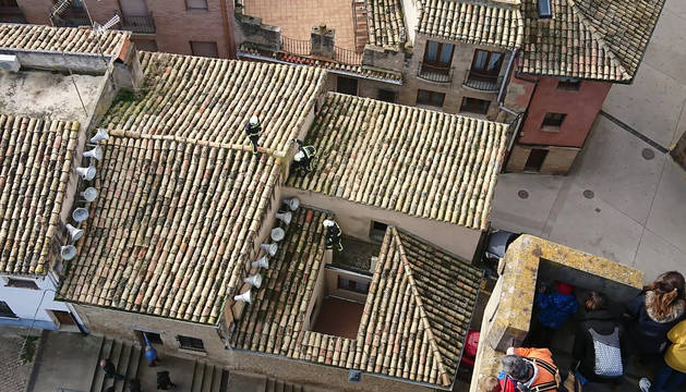 Efectivos de Bomberos de Navarra revisan el tejado y la chimenea donde se produjo el incendio.