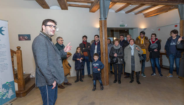 Raúl Rubio, a la izquierda, explica la exposición a los asistentes a la inauguración.