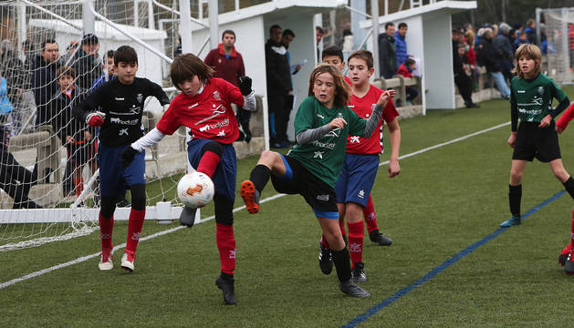 El defensa del Ángel Martínez Baigorri despeja un balón peligroso, mientras que un jugador del Hegoalde intenta cortarlo.