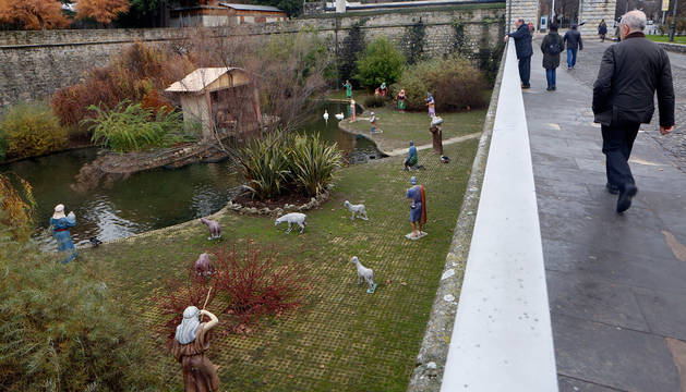 foto de Un hombre camina junto a los fosos de la Taconera, en el estanque de 'los patos' donde está instalado el belén.