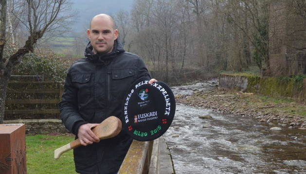 Xabier Ibargarai posa en la margen del río Bidasoa junto a la txapela 'Elosegui' de campeón y la pala 'Euskalduna' con la que conquistó su primer título individual.