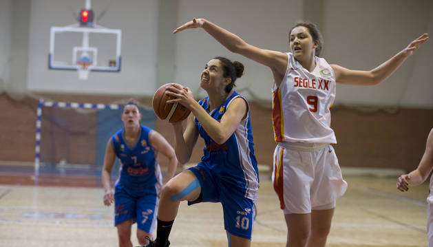 Foto de la alero del Osés Construcción Beatriz Royo penetra a canasta tras superar a Helena Pueyo, la máxima anotadora del partido con 22 puntos.