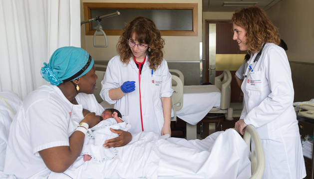 foto de Fily Traore y su hija Niagale Fofana, atendidas por dos profesionales en su habitación del hospital.