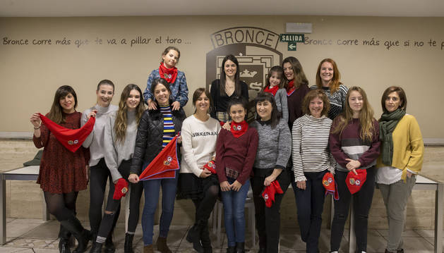 Desde la izquierda, Marta Muro López, Sandra Caloev, Marta Iriarte Satrustegi, Marina Curiel, con su hija Ane Sádaba Curiel; Maite Cambra Preciado, Iranzu Gallo Mendoza (de pie), Sheila Nieto Salmerón, Mari Carmen Oskariz Yagüe; Arriba, Saioa Garate González, Maider Villava González y Vanesa González Gota; debajo, Gloria Burgui Benito, Sara Sáenz Zabalza y Ana Goyén Goyén. Las quince son socias de Los de Bronce, algunas desde que nacieron; otras, pioneras. La igualdad asoma también a las peñas.