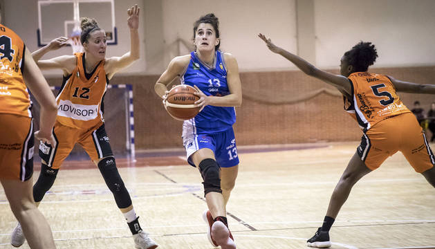 La capitana del Osés, Itziar Arregui, penetra con decisión ante Itziar Llobet y Silvia Diao.