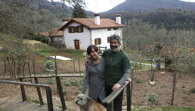 Alicia Mendive y Luismi Montoya, en el acceso a la cabaña en el árbol junto a su casa, al fondo, en Villanueva de Arce.
