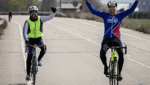 Gesto de victoria y alegría de dos ciclistas en el tramo final de la bajada del puerto de Loiti, en la Javierada.