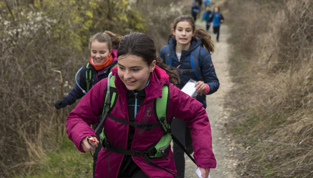 Tres jóvenes deportistas, con el mapa en la mano, corren por los senderos de San Cristóbal-Ezkaba en busca de una de las balizas 'escondidas' que deben localizar con las pistas y por las que deben pasar para puntuar.