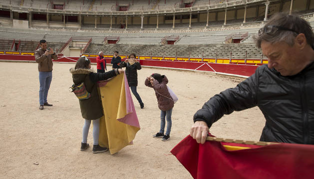 La visita a la plaza acaba en el ruedo, donde los visitantes aprovechan para hacerse fotos con las muletas y los capotes.