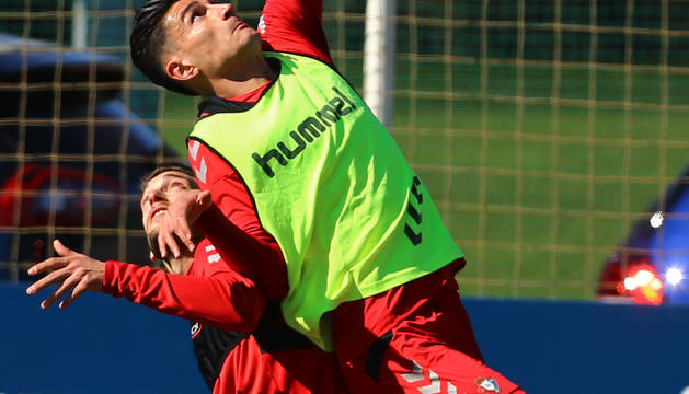 Luis Perea coge impulso en busca del balón junto a Roberto Torres, este jueves en Tajonar.