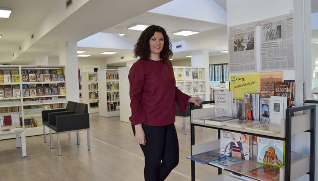 Foto de Laura Romero Díaz, bibliotecaria de San Adrián, junto al centro de interés que ofrece información sobre la cultura, literatura, gastronomía y religión musulmanas tanto para adultos como para niños.
