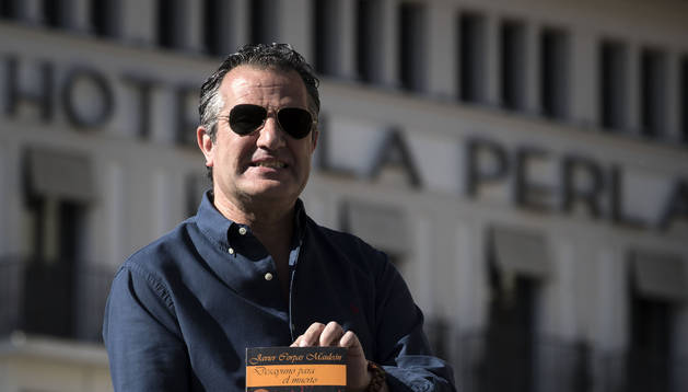 Jesús Javier Corpas, en el quiosco de la Plaza del Castillo. Al fondo, el hotel La Perla, escenario recurrente en su novela.