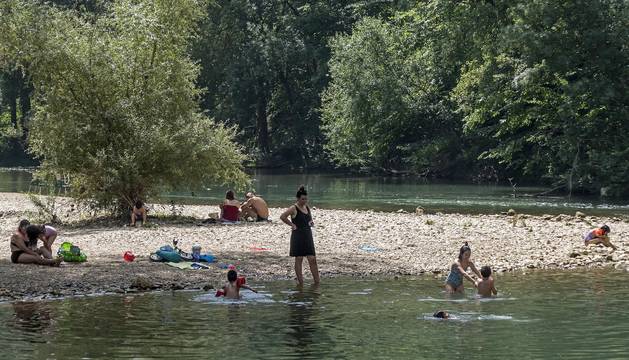 Bañistas en el río Ega en el paseo de Los Llanos de Estella durante la ola de calor de la semana pasada.