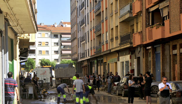 Foto de trabajos de desciegue y limpieza, ayer, en la calle Martínez de Espronceda, una de las más afectadas por las inundaciones del pasado lunes. Los coches volvían a estar aparcados en la zona.