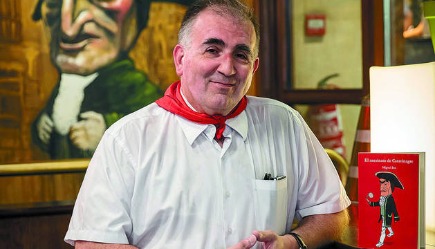 Acodado en el bar-cafetería Caravinagre y con un ejemplar inspirado en su figura, el escritor Miguel Izu Belloso esboza una sonrisa.