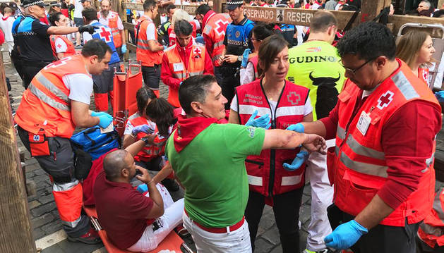 Los miembros de Cruz Roja atiende a una persona en el puesto de