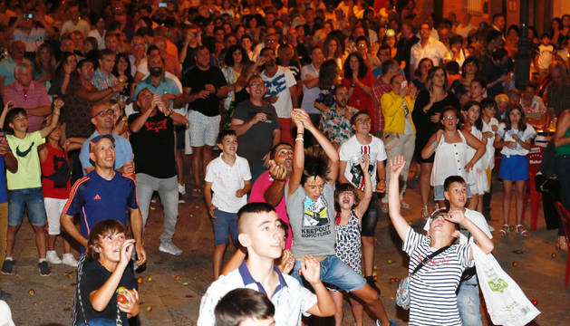 Un grupo de asistentes intenta coger las peras que se lanzaron en este tradicional acto.