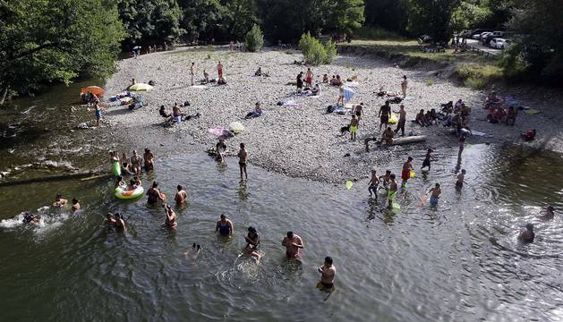 Decenas de personas buscaron ayer refrescarse en el agua del río Arga a su paso por Irotz.