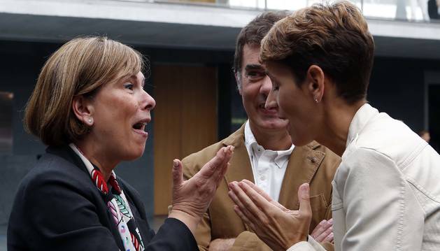 Foto de la socialista María Chivite habla con Uxue Barkos (Geroa Bai) ayer en el atrio del Parlamento, con el secretario general de Podemos, Eduardo Santos, de testigo.