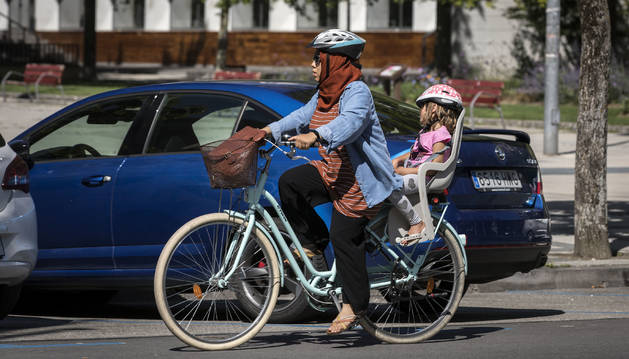 Foto de una mujer y una niña circulan en bici cumpliendo con la normativa de hacerlo por la calzada