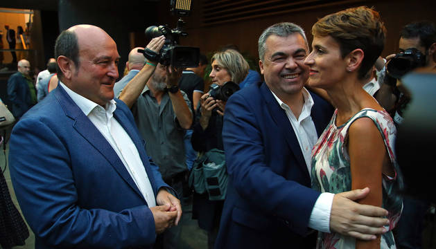 Foto de Chivite con Santos Cerdán (PSN) mientras Andoni Ortuzar (PNV) espera para saludarla.