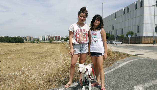 Las hermanas Noa y Kira Rodríguez Belzunce en la carretera donde la víbora le picó a su perra Luna, junto a ellas.