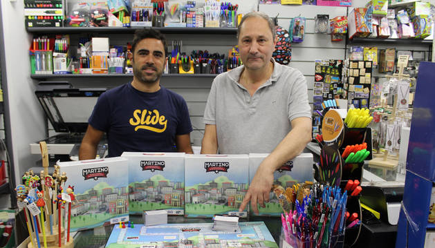 Foto del diseñador del juego, Martín Archanco Rodríguez, y el promotor, el librero Ino Illanes con el tablero y varios ejemplares.