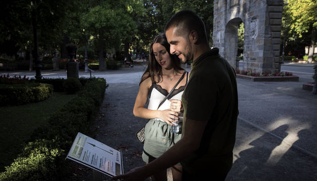 Una pareja observa el panel de la Taconera que señala la secuoya del parque y su relación con la reina americana Braulia de la Comparsa de Gigantes.