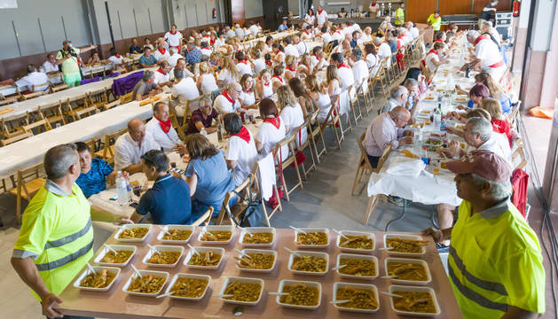 ¡A COMER! Los miembros de la brigada reparten los platos de garbanzos con cigalas y rape en el salón cultural.