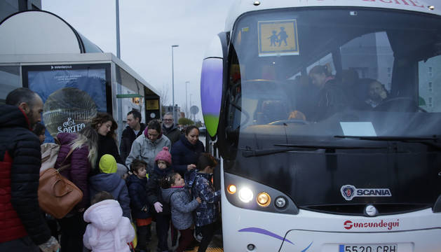 Familias y alumnos aguardan en la parada para subir al autobús escolar de Ardoi. La foto fue tomada en Zizur hace unos días. Navarra destinó 14,5 millones de euros en 2018 al transporte escolar.