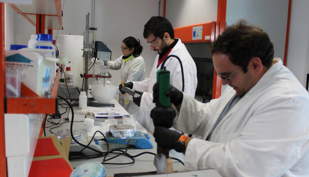 Foto de tres empleados del centro L'Urederra trabajan en uno de los proyectos en el laboratorio.