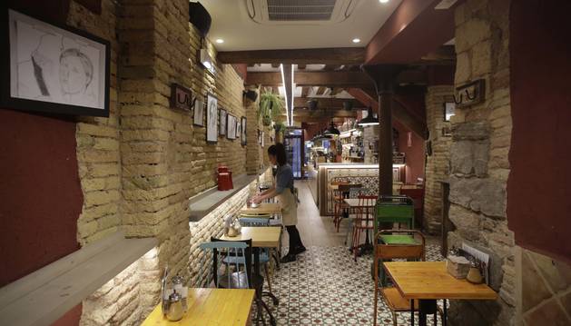 Foto de mesas y sillas en el interior del Café Fika, en la calle Pozoblanco del Casco Antiguo de Pamplona.
