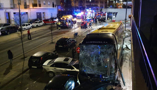 Los equipos de emergencias trabajan en la zona con el autobús siniestrado en primer término.