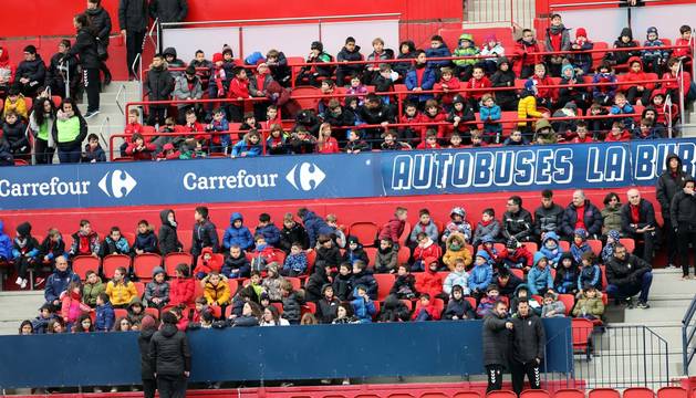 Foto de niños de las escuelas de fútbol de Fundación Osasuna presenciando el entrenamiento de Osasuna en El Sadar el 7 de marzo.