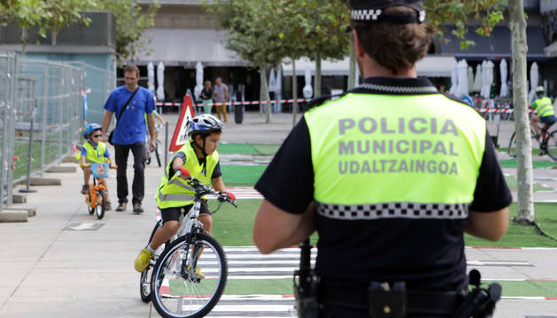 Una agente de la Policía Municipal de Pamplona, durante una campaña de uso del caso en bicis para menores.