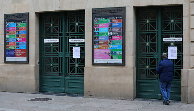 Foto de un hombre leyendo este viernes el aviso colocado en las puertas del Teatro Gayarre. Permanecerá cerrado, en principio, hasta el próximo día 27.