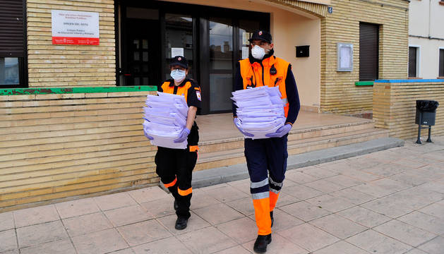 foto de Joana Cajidor (izda.) y Osama Ihdi salen del colegio de Caparroso con las tareas para los alumnos.
