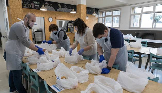 Un grupo de voluntarios y trabajadores de Villa Javier prepara los taper para entregar a los usuarios.