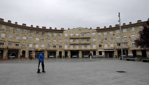 Foto de dos personas atravesando la plaza Mutiloa de Mutilva durante la pandemia de coronavirus.