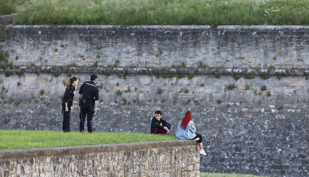 Dos agentes de la Policía Nacional hablan con una pareja de jóvenes en la Ciudadela durante la salida a la calle para hacer ejercicio.