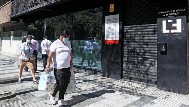 Varias personas pasan por delante de la delegación de Hacienda en la calle Esquíroz.