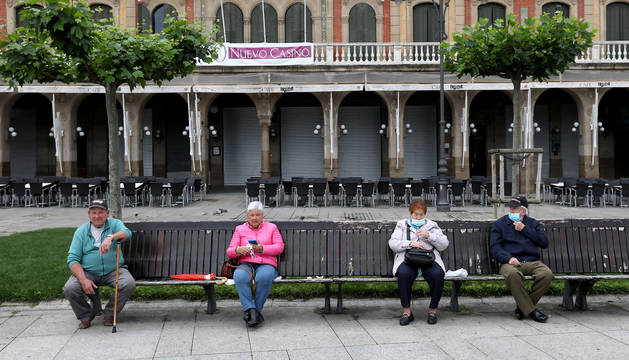 El clima desapacible de ayer no impidió que los vecinos de Pamplona disfrutaran de la calle. En la foto, en un banco de la plaza del Castillo.