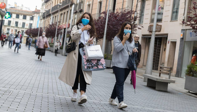 FOTO DE Dos jóvenes, con bolsas de compra, pasean por la calle Gaztambide-Carrera de Tudela.
