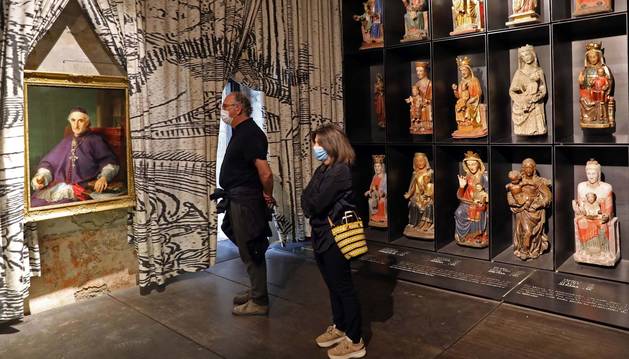Foto de dos personas visitando la exposición Occidens en la catedral de Pamplona.