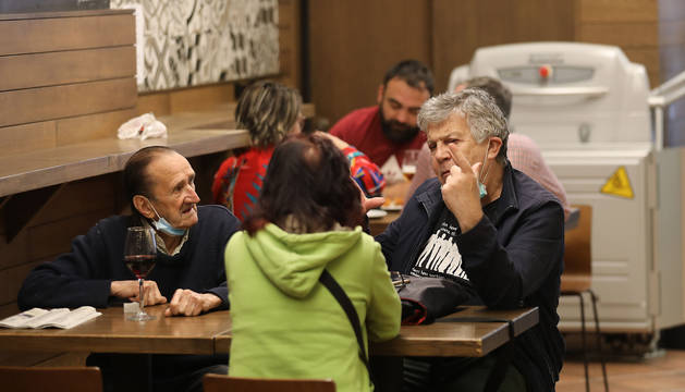 Foto de un grupo de clientes, en sus respectivas mesas, en el Bodegón Sarria, en la Estafeta.