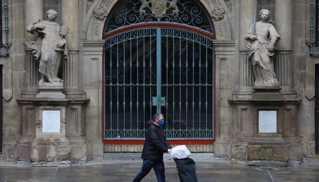 Un transeúnte pasa ante la fachada del Ayuntamiento de Pamplona el pasado mes de abril.