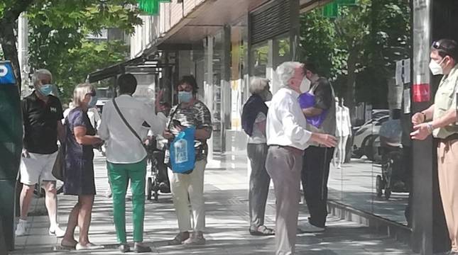 El vigilante de seguridad informa a un contribuyente de las reglas para ser atendido mientras otro grupo de afectados comparte su malestar.