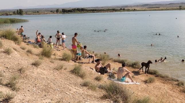 Muchas cuadrillas y familias disfrutan de bañarse y tomar el sol en hamacas y toallas a la orilla de la balsa El Pulguer, única zona de baño natural en la Ribera.