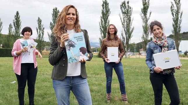 De izda a dcha: la psicóloga sanitaria Patricia Díez Lecumberri, las maestras Lorea Nagore Iriarte (Primaria) y Almudena Moya (Infantil) y la ilustradora Beatriz Menéndez, con el material del proyecto educativo 'Alumbrando túneles. Covid 19', en una pradera de Olloki.