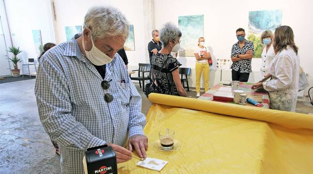 Juan Osés y Susana Arancón, con los asistentes a una visita guiada a las exposiciones. Juan Oses dibujó sobre manchas de café y la artista tudelana explicó su pintura matérica.
